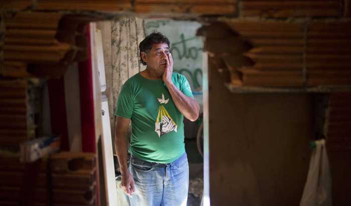 کارگر برزیلی پیش از تخریب آلونک‌اش برای ساخت و سازهای المپیک