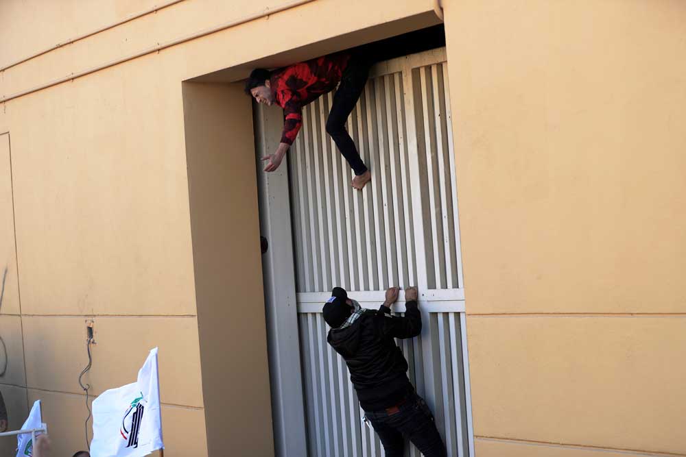 شبه‌نظامیان و نیروهای وابسته به جمهوری اسلامی و حزب‌الله و گروه‌های شیعه از دیوار سفارت آمریکا در بغداد بالا می‌روند؛ ۳۱ ژانویه ۲۰۱۹