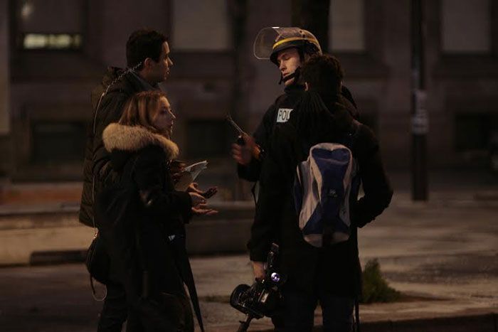خبرنگاری با یکی از افراد پلیس گفتگو می کند