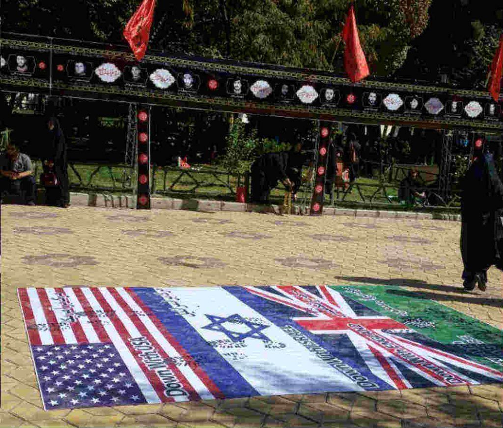 زیرپا انداختن پرچم‌های آمریکا، انگلیس و اسرائیل در مقابل درب ورودی هیات